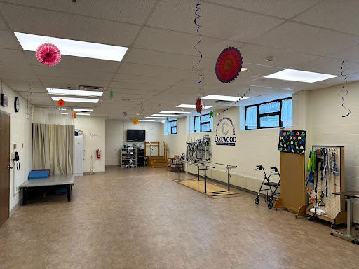 A bright and spacious rehabilitation facility featuring gym equipment and areas for patient activities.