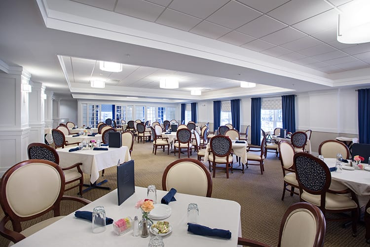 An elegantly set dining room with neatly arranged tables and chairs.