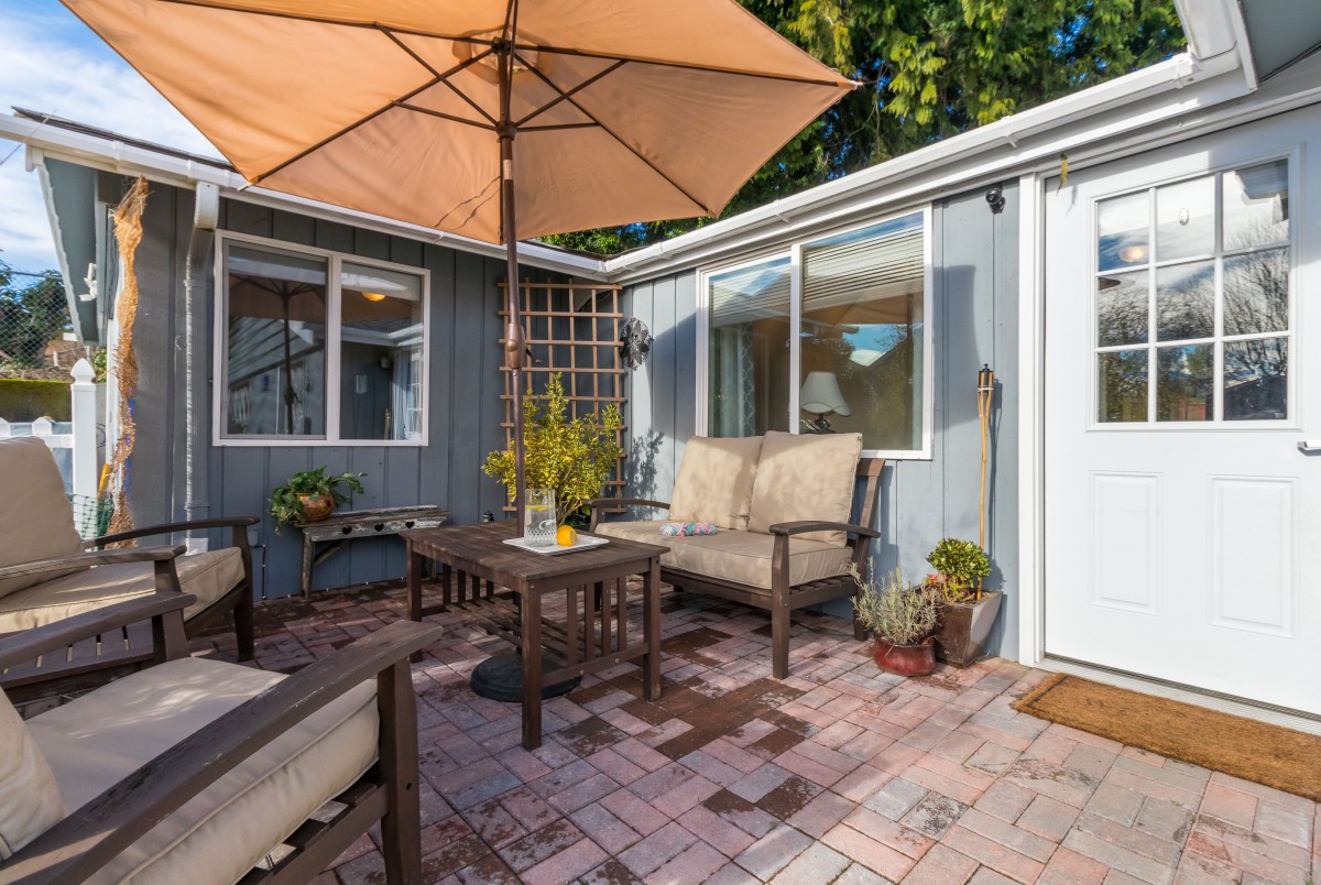 Cozy patio area with comfortable seating and an umbrella, perfect for relaxation.
