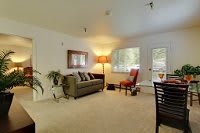 A cozy living room with a sofa, chair, and warm lighting.