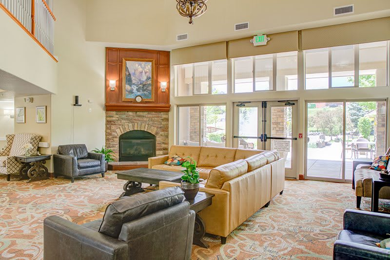 A cozy lobby area with comfortable seating, a fireplace, and large windows letting in natural light.