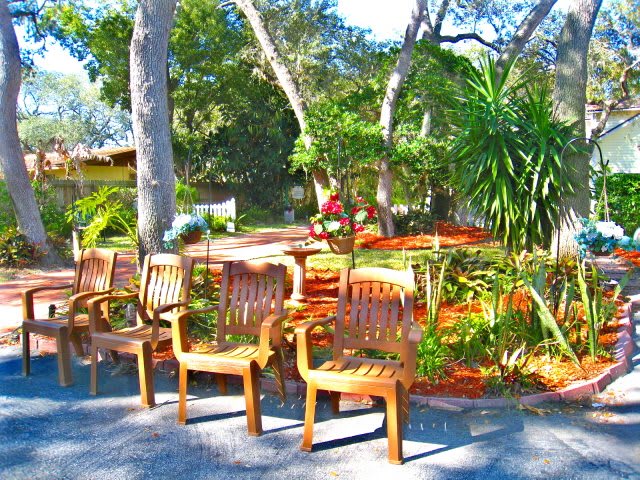 A tranquil garden with wooden chairs and lush greenery.
