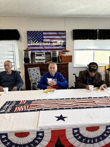 A group of veterans enjoying a meal together in a community space decorated with an American flag.