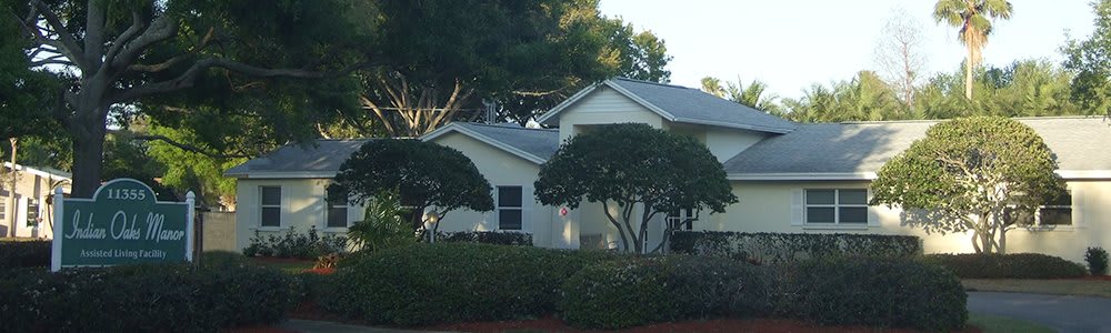 A suburban house surrounded by trees on a clear day.
