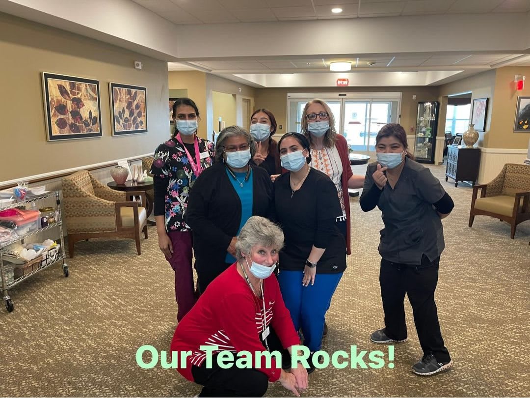 A group of team members posing together, wearing masks, with the text 'Our Team Rocks!'