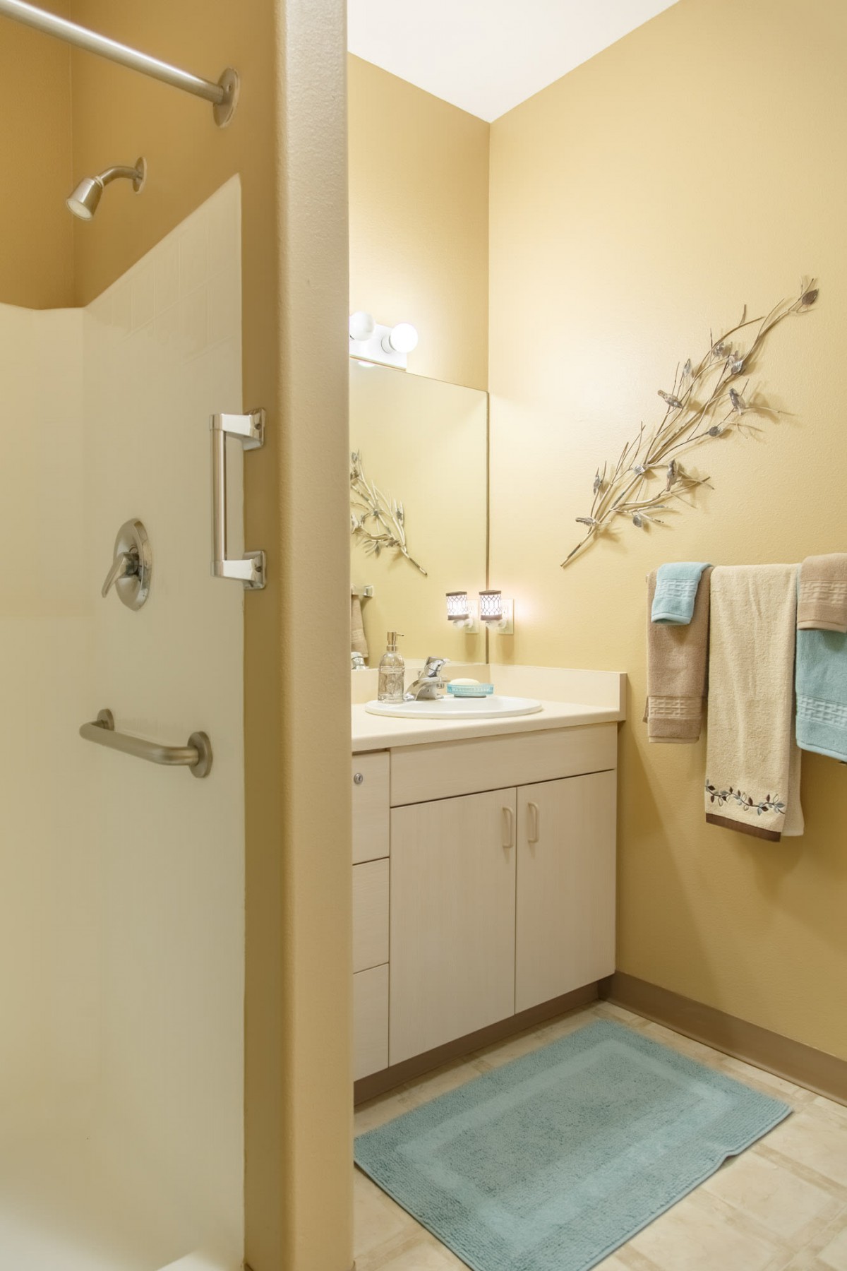 A neatly organized bathroom with a shower, sink, and decorative elements.