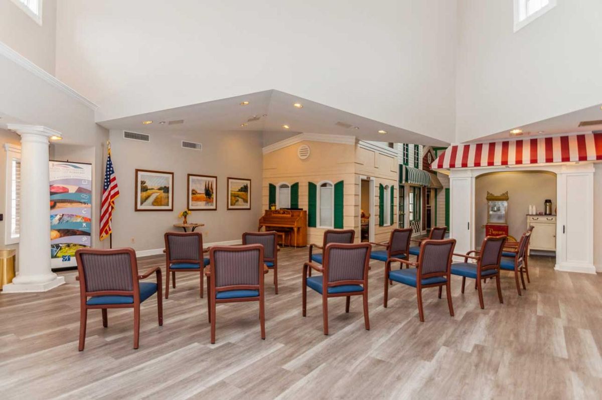 A community meeting area with arranged chairs, a piano, and artwork on the walls.