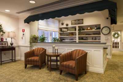 A cozy reception area featuring two comfortable chairs and a side table, adorned with plants and decorative shelves.
