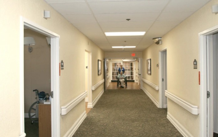 A long hallway with a carpet and several doors on either side.