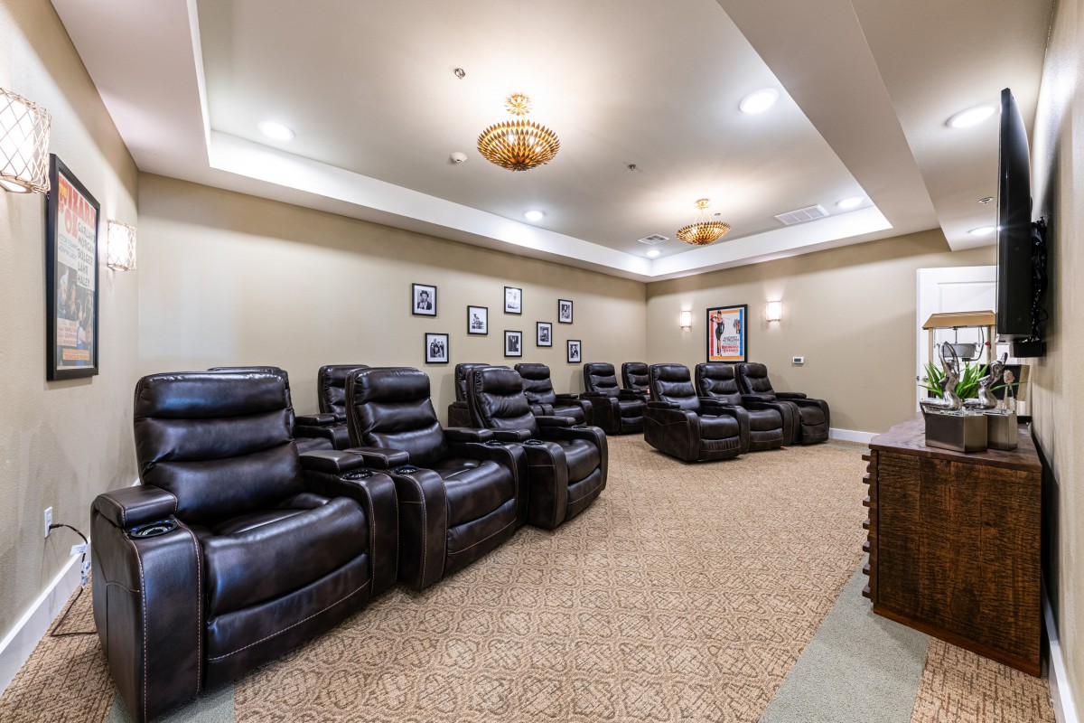 A luxurious home theater room with multiple leather recliners and wall decorations.
