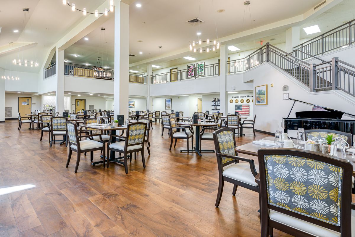 A spacious and well-lit dining area with multiple tables and chairs, showcasing a modern interior design.