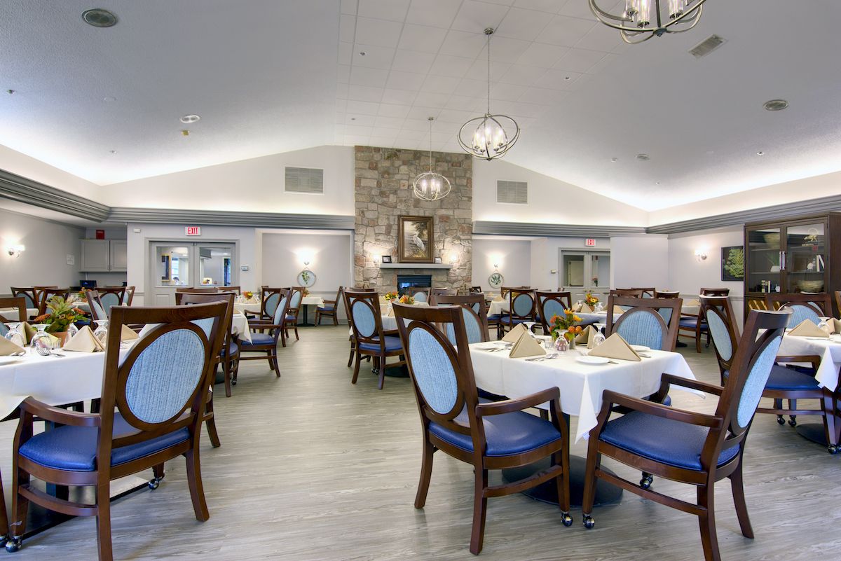 A well-decorated dining room featuring elegant seating and a central stone fireplace.