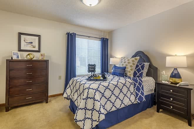 A well-decorated bedroom with blue and white bedding and matching curtains.