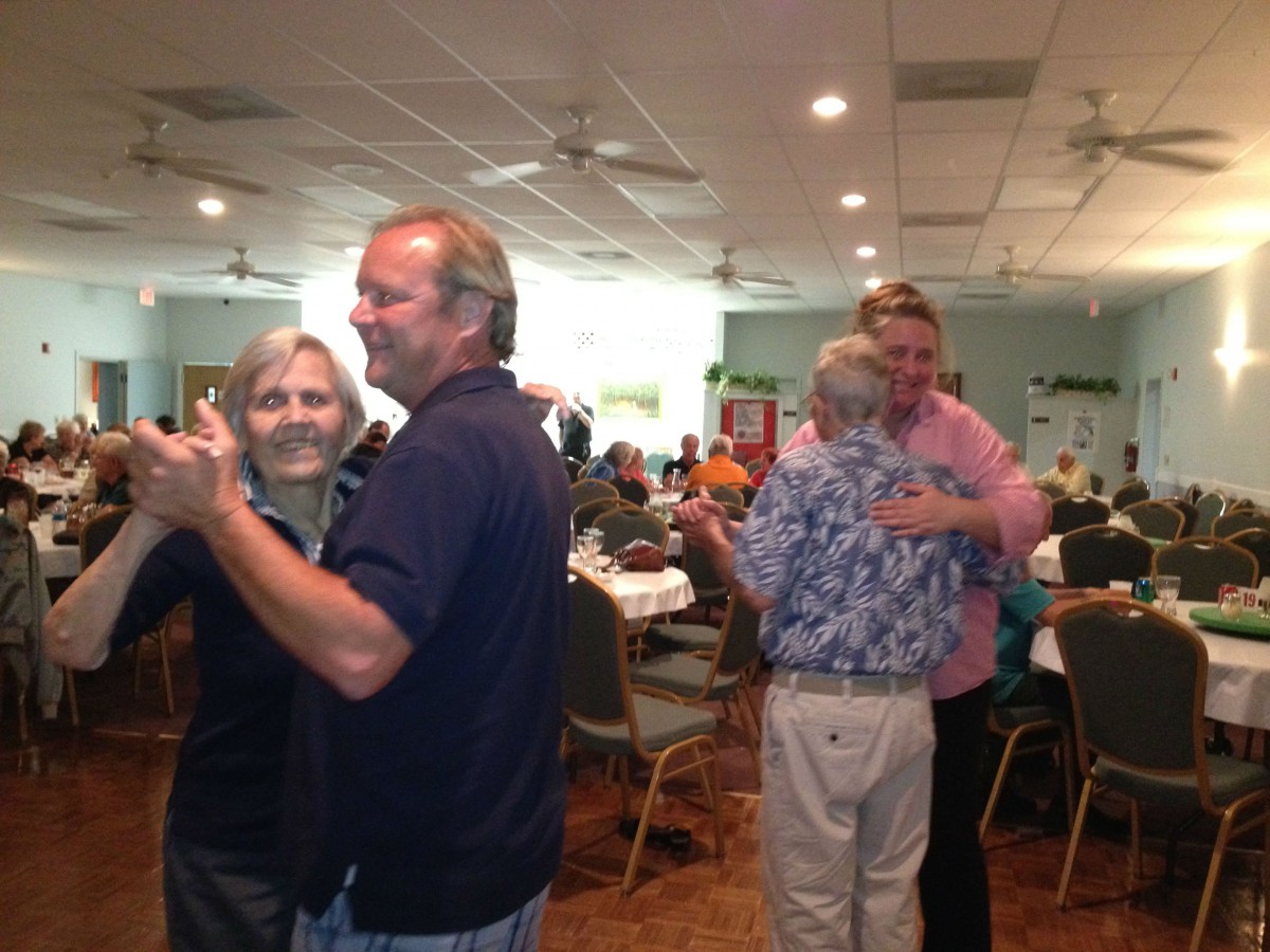 Couples dancing at an indoor social event.