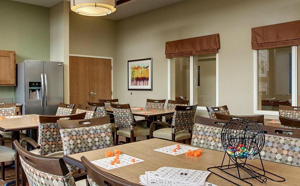 A well-arranged dining room with multiple tables and chairs, decorated with artwork and soft lighting.