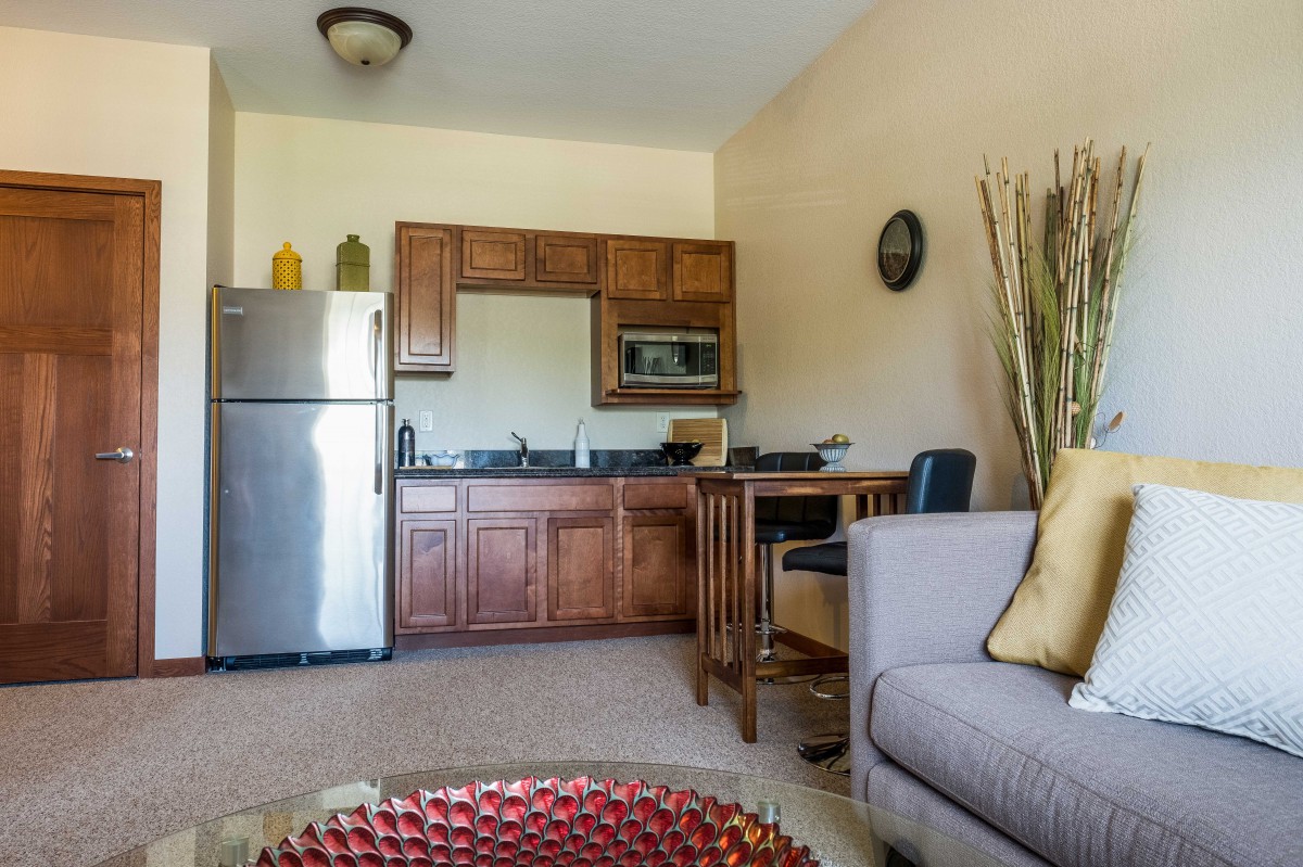 A cozy apartment interior featuring a small kitchen and living area.