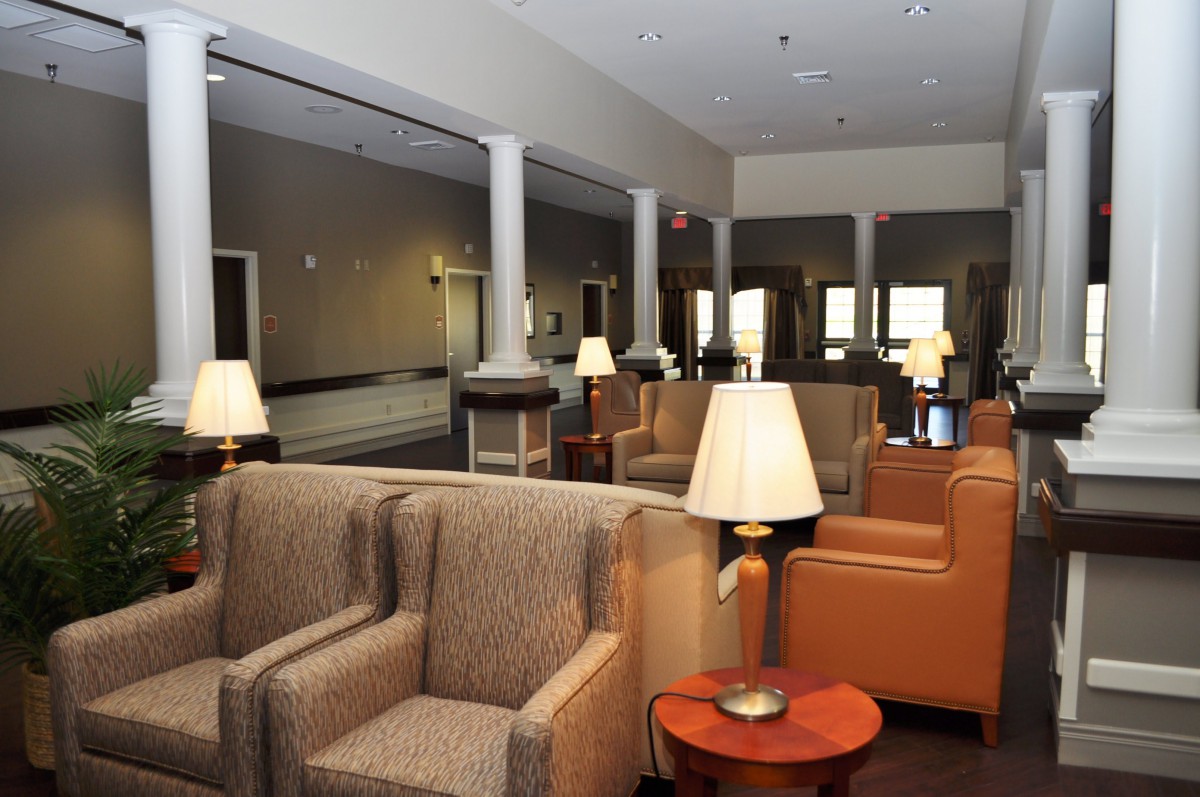 A spacious hotel lobby featuring comfortable armchairs and warm lighting.