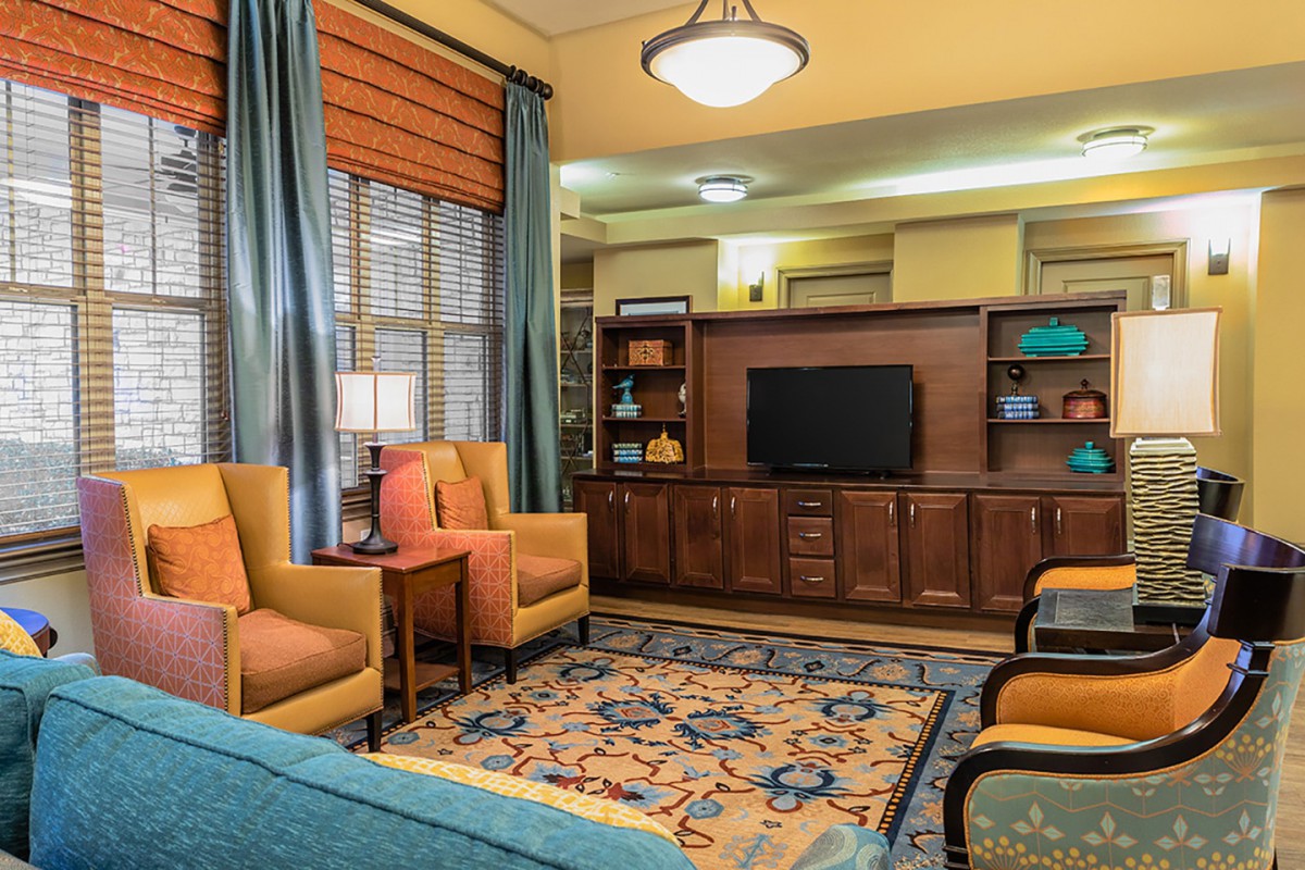 A cozy living room with comfortable armchairs, a television, and elegant decor.