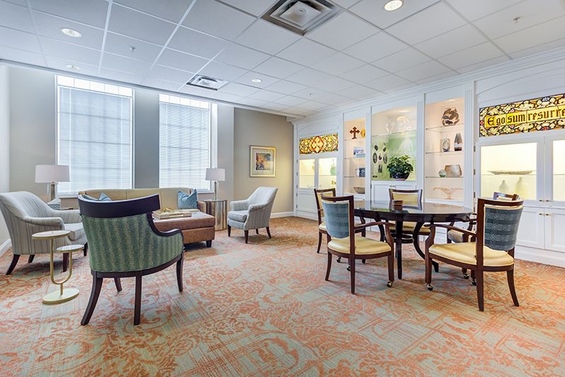 A cozy lounge area with armchairs and tables, featuring soft lighting and tasteful decor.