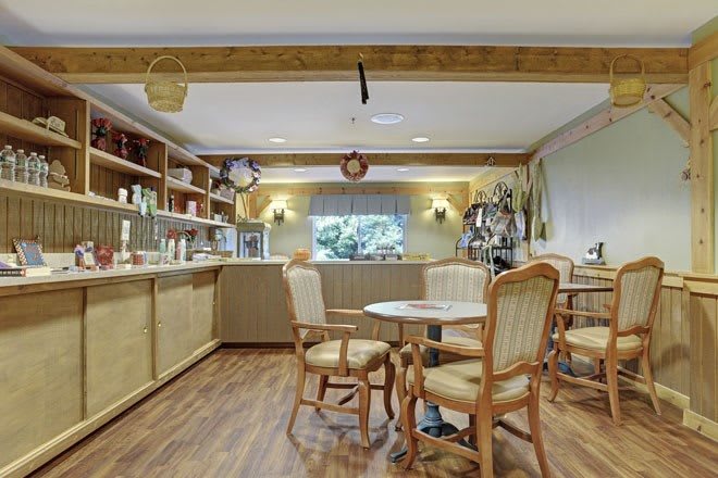 A cozy cafe interior with wooden furniture and a display counter.