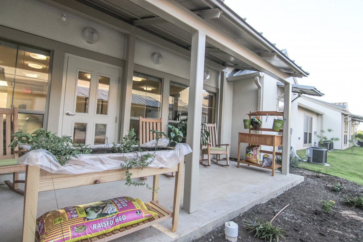 A cozy porch area with garden tables and potted plants.