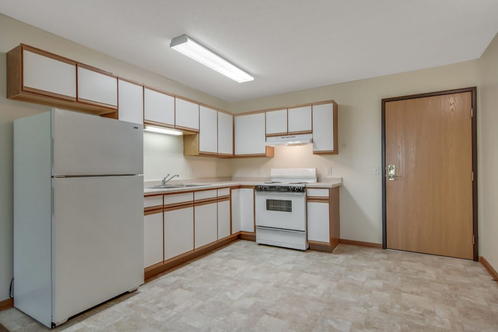 A spacious kitchen with white cabinets and appliances.