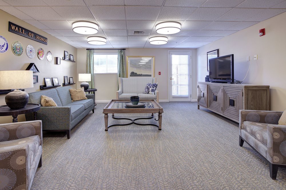 A well-lit living room featuring a comfortable sofa, coffee table, and television setup.