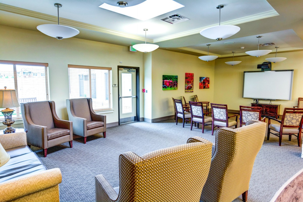A spacious and well-lit waiting room with comfortable seating and a conference table.