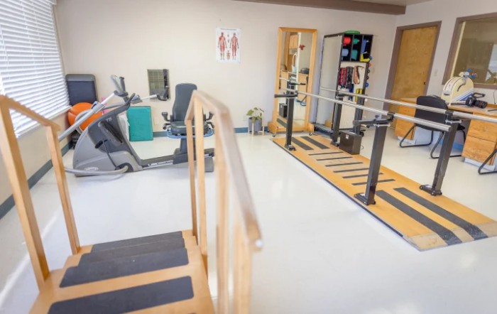 A physical therapy room equipped with various rehabilitation and exercise machines.