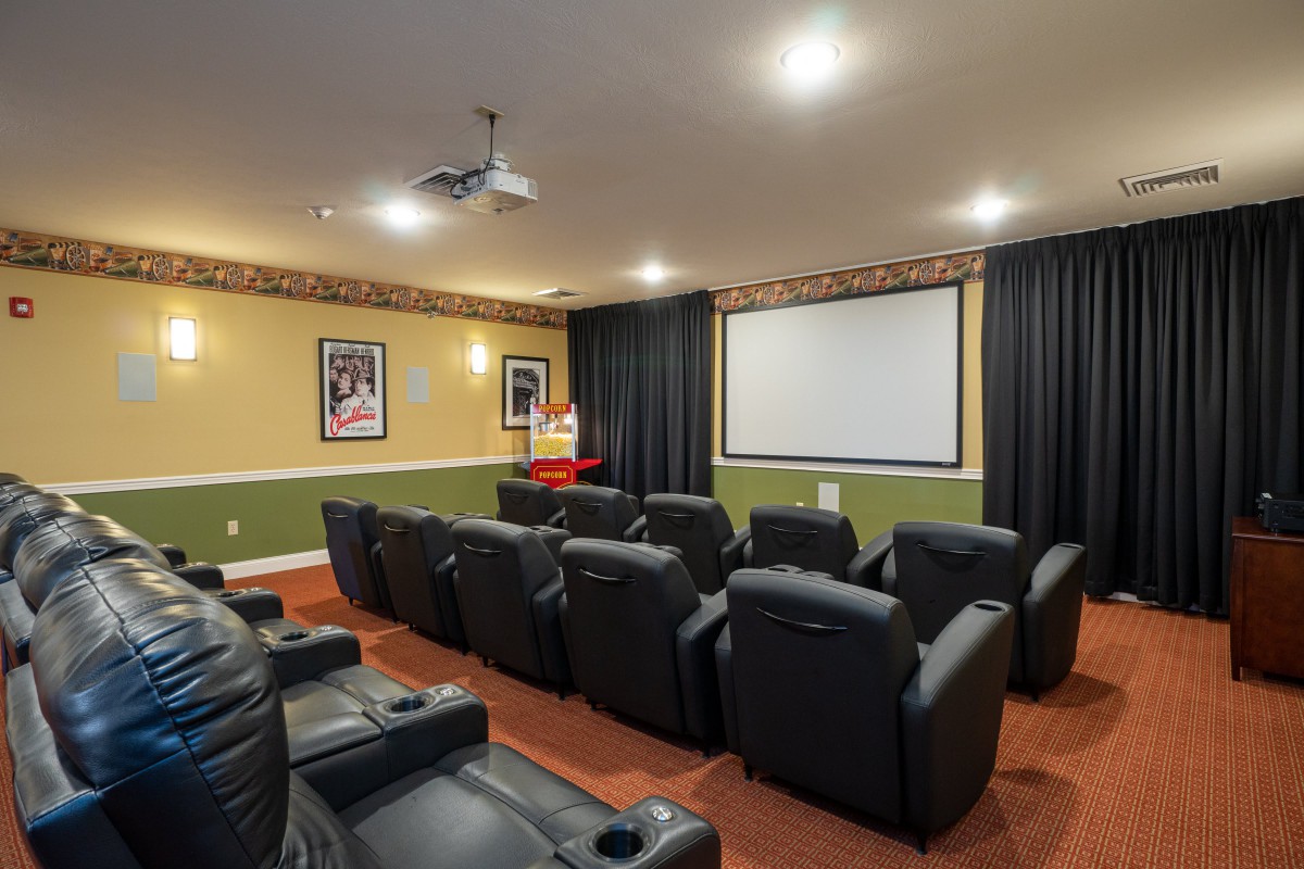 A cozy home theater featuring several recliner seats facing a large projector screen, perfect for movie nights.