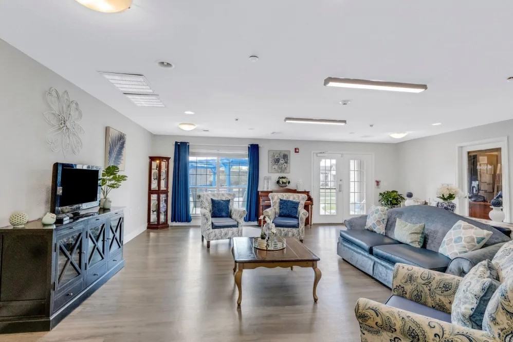 A spacious and elegantly decorated living room with blue accents and modern furniture.