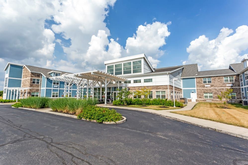 A modern building with a landscaped entrance and a clear blue sky.