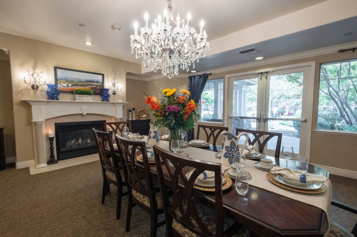 Elegant dining room with a chandelier, set for dinner.