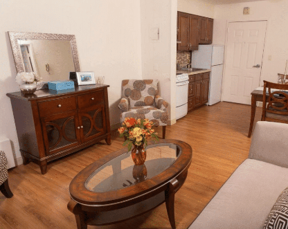 A cozy living area with a kitchenette, featuring elegant furniture and decor.