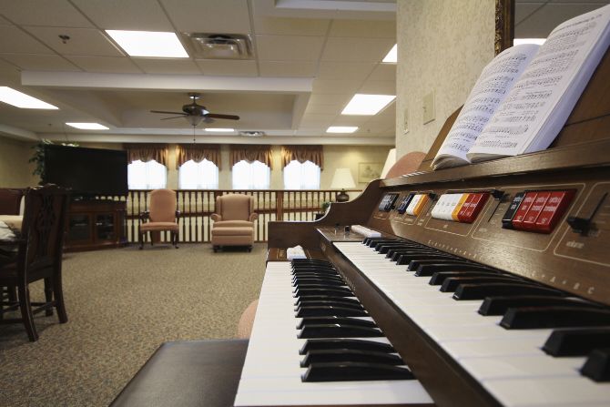 A cozy room with a piano and sheet music, featuring comfortable seating.