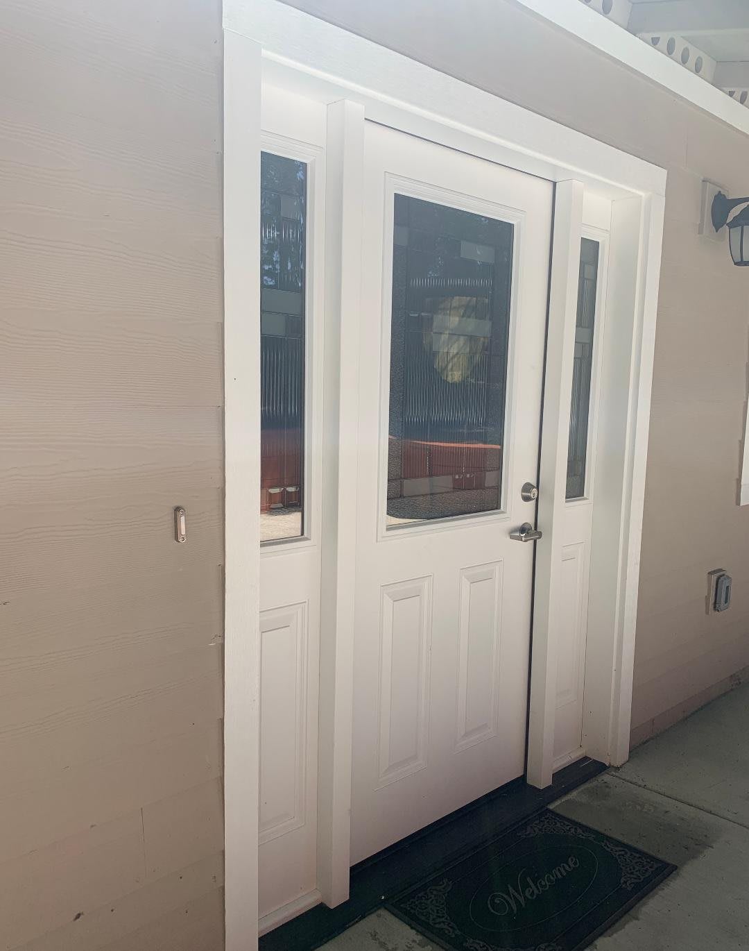 A white exterior door with glass panels leading into a building.