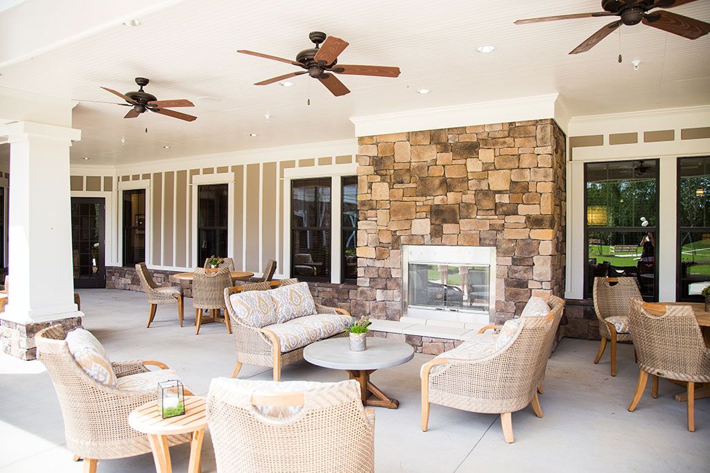 A cozy outdoor patio with comfortable seating and a stone fireplace, perfect for relaxation.