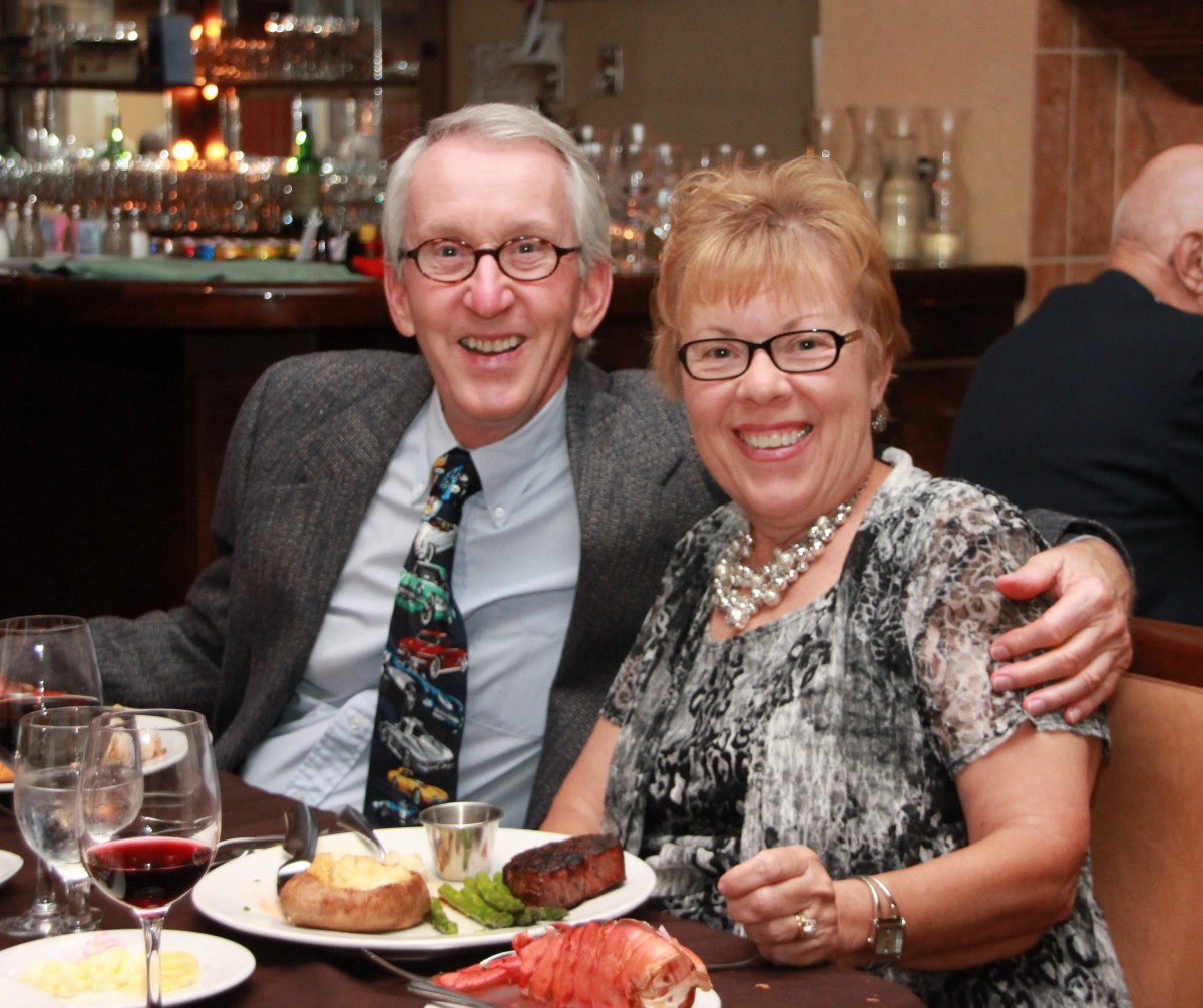 A cheerful couple enjoying a formal dinner with wine at a restaurant.