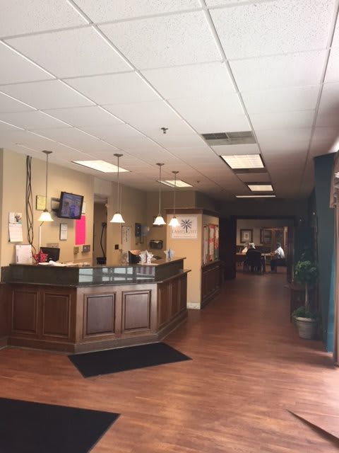 A reception area with a desk and wooden flooring.