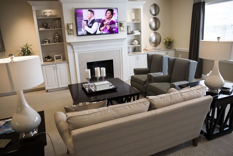 A cozy living room with a fireplace, sofa, and television.