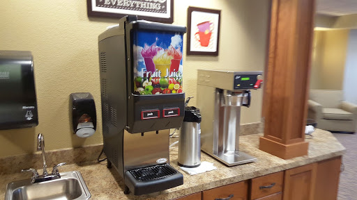 A beverage station featuring a soda fountain and a coffee machine.