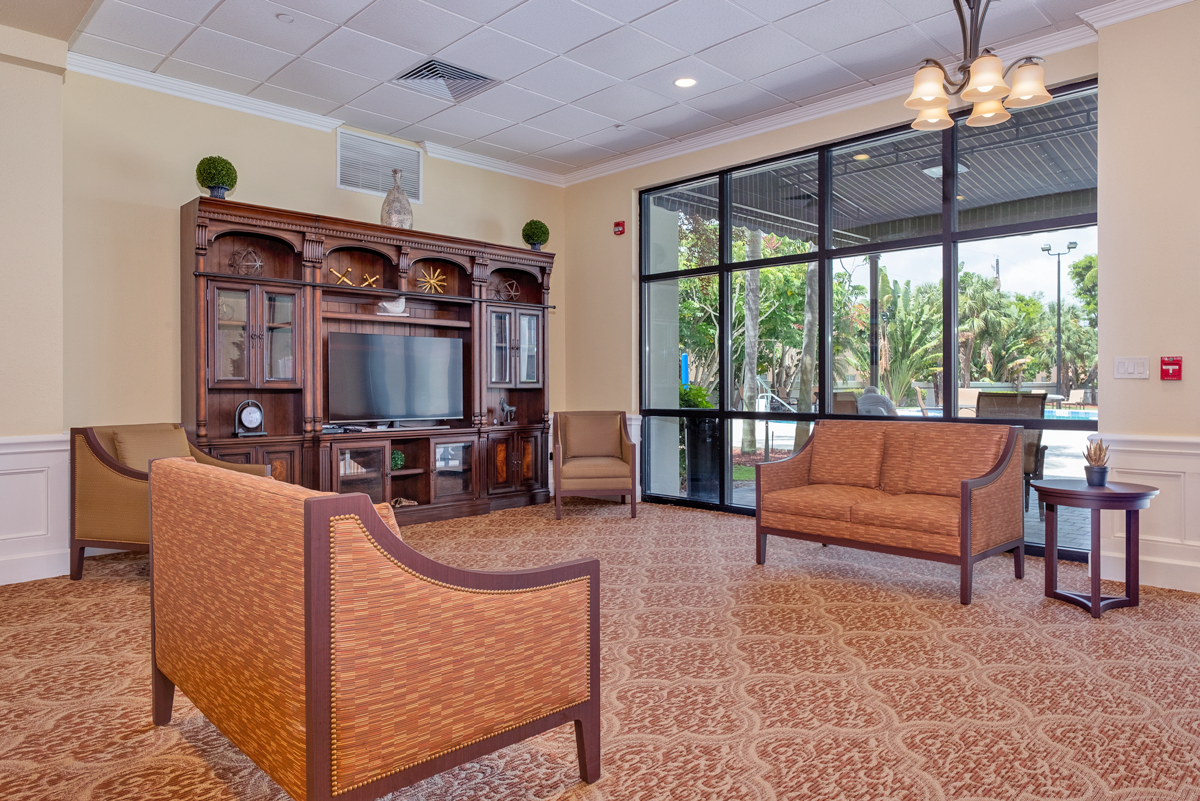 A spacious lobby with comfortable seating, a television, and large windows allowing natural light.