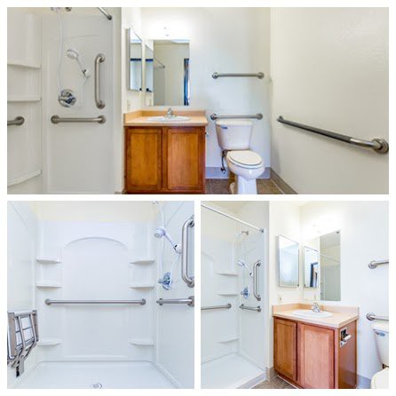 An accessible bathroom equipped with grab bars, a spacious shower, and a sink area.