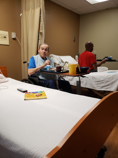 Patients in a hospital room sharing a meal.