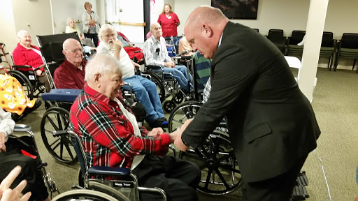 A meaningful interaction between a caregiver and an elderly resident during a community event.