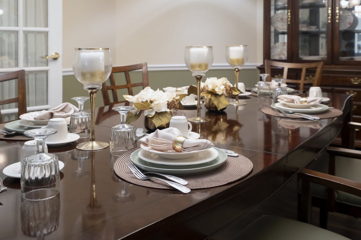 An elegantly set dining table with candles and floral decorations.