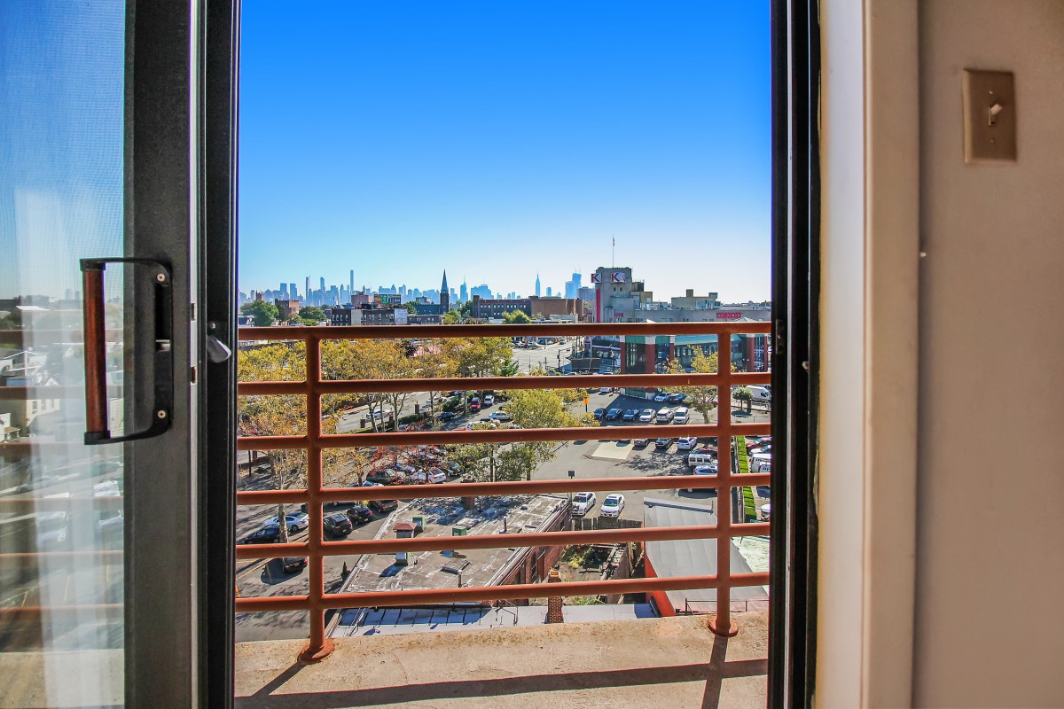 View from a balcony overlooking a cityscape with clear blue skies.