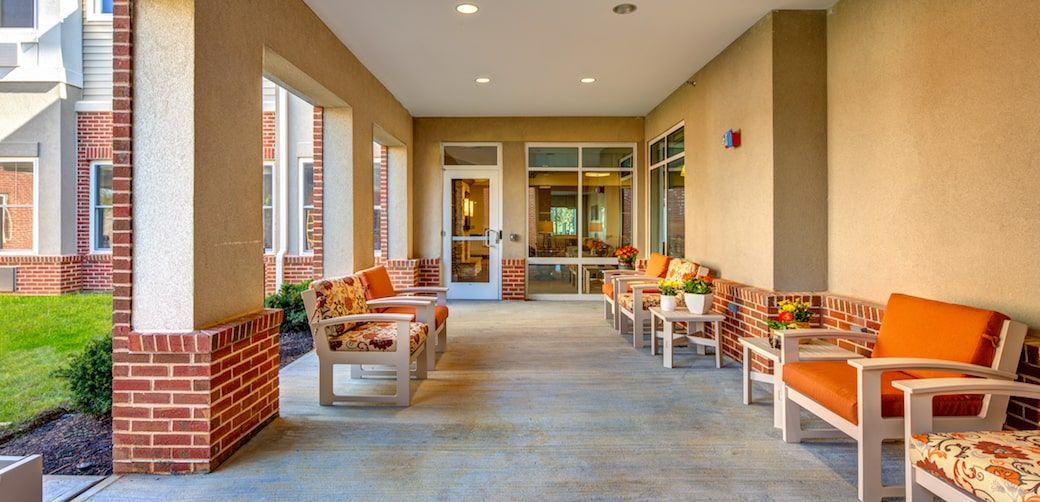 A cozy outdoor patio with wooden benches and colorful cushions.