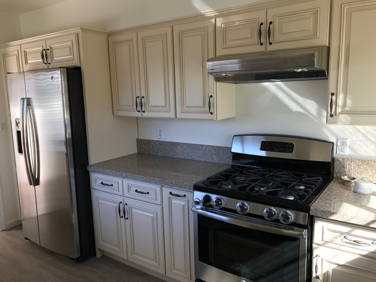 Modern kitchen with stainless steel appliances and light-colored cabinets.