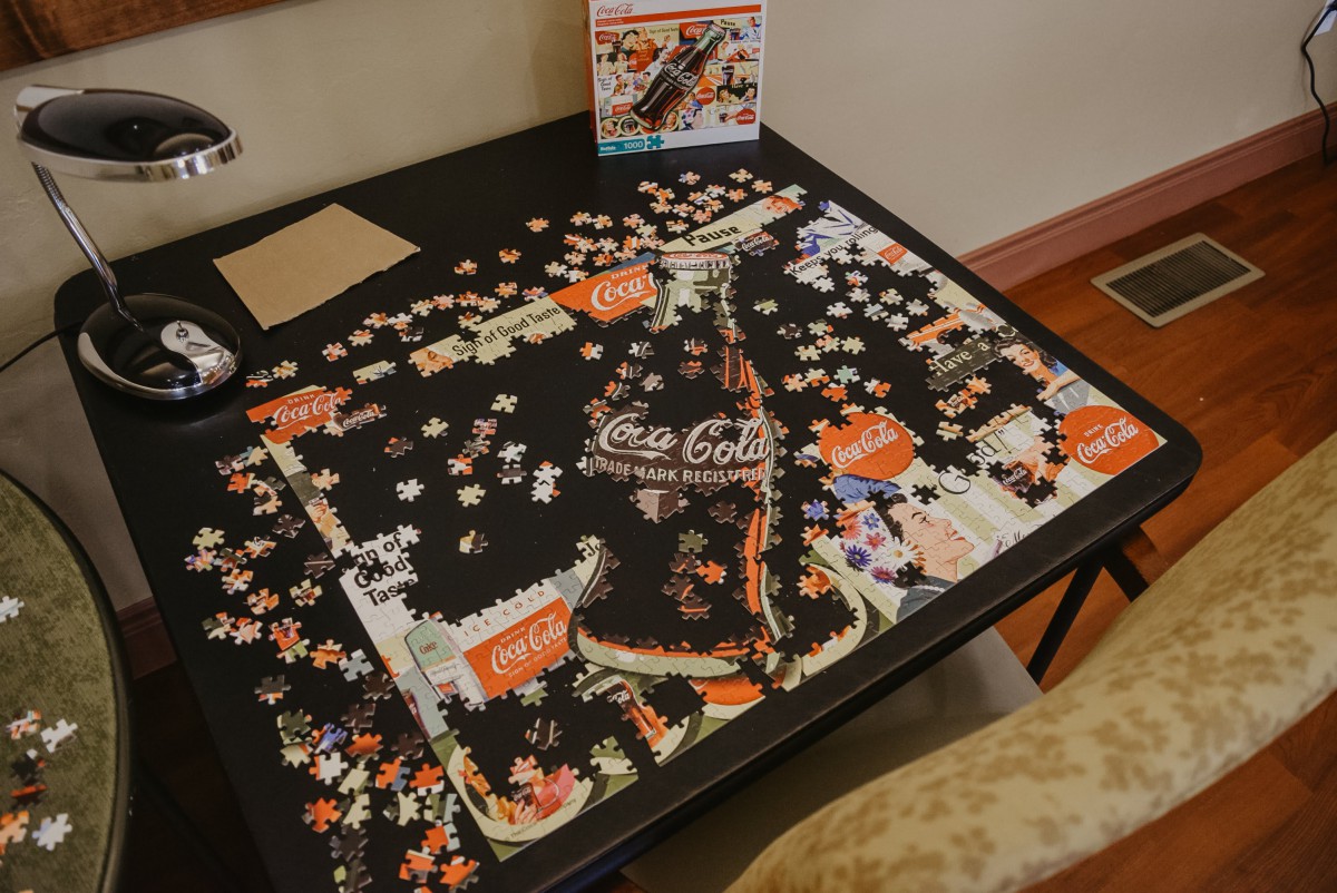 A partially completed Coca-Cola themed jigsaw puzzle on a table.